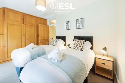 a bedroom with two beds and a dresser in it at Town Centre Cosy 1 Bedroom Cottage in the Heart of Shrewsbury in Shrewsbury