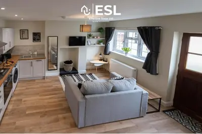 a living room with a couch and a kitchen at Town Centre Cosy 1 Bedroom Cottage in the Heart of Shrewsbury in Shrewsbury