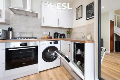 a kitchen with a washer and dryer in a kitchen at Town Centre Cosy 1 Bedroom Cottage in the Heart of Shrewsbury in Shrewsbury