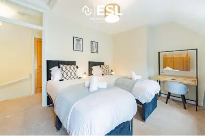 a bedroom with two beds and a desk in it at Town Centre Cosy 1 Bedroom Cottage in the Heart of Shrewsbury in Shrewsbury