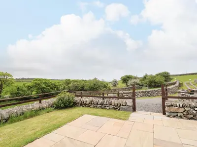 an image of a stone fence and a stone walkway at Caerffynon Bach in Dyffryn