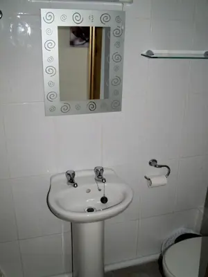 a bathroom with a white sink and a mirror at The Calf Suite in Aberystwyth