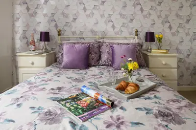a bed with a tray of food and a plate of bread at Finest Retreats - Golygfa o'r Castell - Castle Views in Harlech