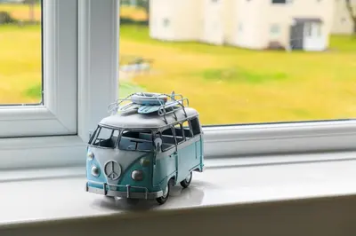 a small toy van sitting on a window sill at Finest Retreats - Golygfa o'r Castell - Castle Views in Harlech