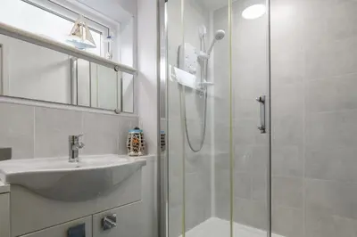 a bathroom with a sink and a shower at Finest Retreats - Golygfa o'r Castell - Castle Views in Harlech