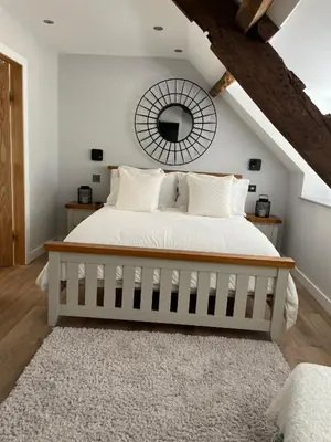 a bedroom with a large bed with a mirror at A cottage for two in Brecon