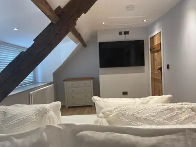 a bedroom with a bed with a television on the wall at A cottage for two in Brecon