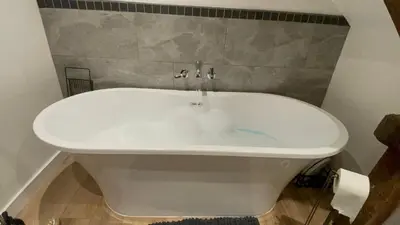 a white bath tub sitting in a bathroom at A cottage for two in Brecon