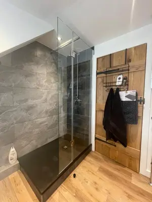 a shower with a glass door in a bathroom at A cottage for two in Brecon