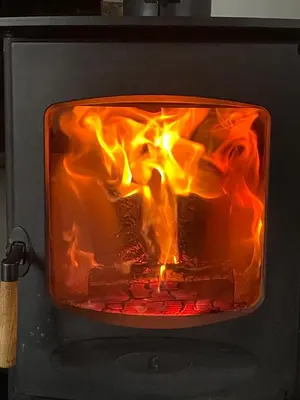 a fire inside of an oven with its door open at A cottage for two in Brecon