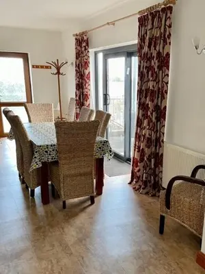a dining room with a table and chairs and windows at Apartment 14 in Aberystwyth