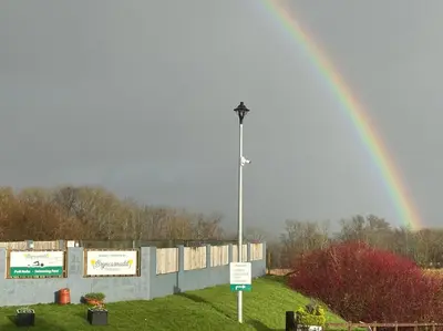 a rainbow in the sky with a street light at Apartment 14 in Aberystwyth