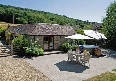 a patio with a table and an umbrella at Garden Cottage at Eaton Manor in Eaton