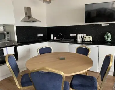 a kitchen with a wooden table and chairs in a kitchen at Ty Bach in Aberystwyth