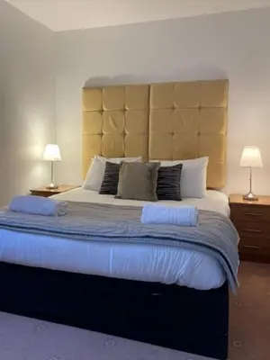 a bedroom with a large bed with two lamps at Ty Bach in Aberystwyth