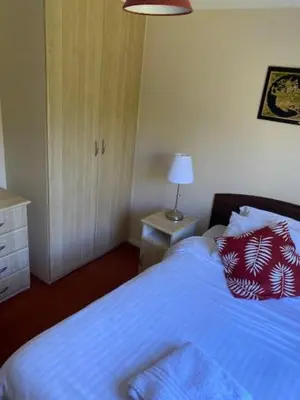 a bedroom with a bed with a blue blanket and a lamp at Lodges at Bryncarnedd, Aberystwyth in Aberystwyth