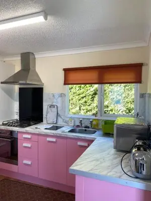 a kitchen with pink cabinets and a large window at Lodges at Bryncarnedd, Aberystwyth in Aberystwyth