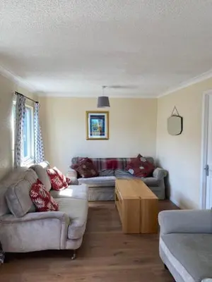 a living room with two couches and a table at Lodges at Bryncarnedd, Aberystwyth in Aberystwyth