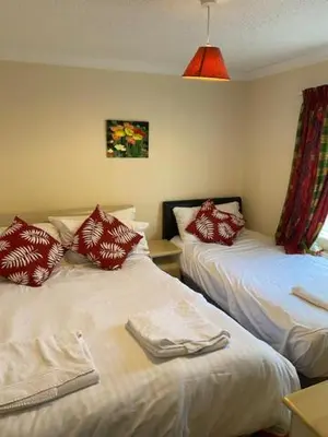 a room with two beds with red and white pillows at Lodges at Bryncarnedd, Aberystwyth in Aberystwyth