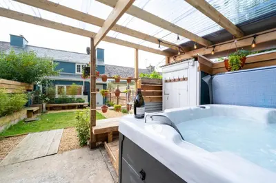 a hot tub in a backyard with a pergola at 2 Bed in Aberaeron oc-bow329 in Aberaeron