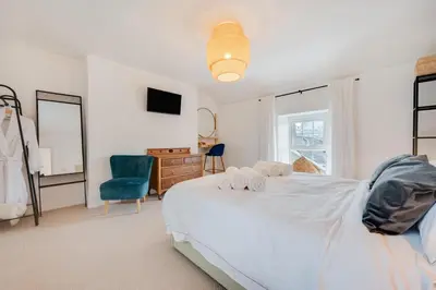 a bedroom with a white bed and a blue chair at 2 Bed in Aberaeron oc-bow329 in Aberaeron
