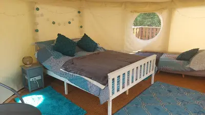 a bedroom with a bed in a tent at Yurt Uchaf Off-Grid Glamping in Machynlleth