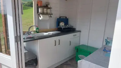 a small kitchen with a sink and a counter at Yurt Uchaf Off-Grid Glamping in Machynlleth