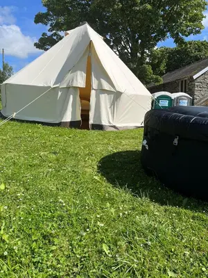 a large white tent sitting in the grass at Tipi - Pengarreg in Aberystwyth