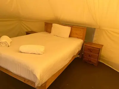 a bed in a tent with two towels on it at Tipi - Pengarreg in Aberystwyth