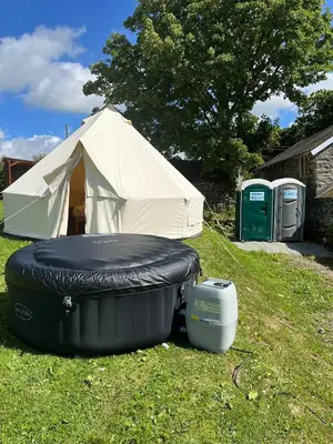 a tent and a mattress and a cooler in a yard at Tipi - Pengarreg in Aberystwyth