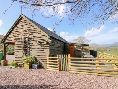 a wooden cabin with a fence in front of it at The Retreat in Oswestry