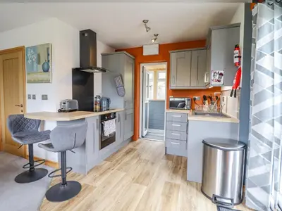 a small kitchen with a counter and a table at Bryn Hyfryd in Talsarnau