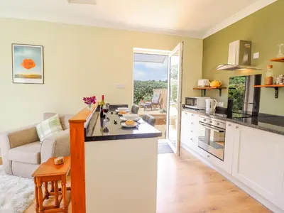 a kitchen and living room with a couch and a counter at Cam O'r Fechan Annexe in Llangollen