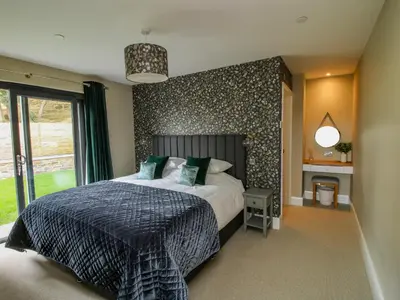 a bedroom with a large bed with a wall at Llety Cariad in Montgomery
