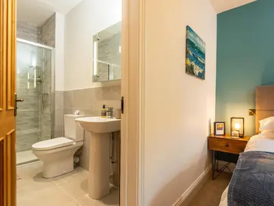 a bathroom with a toilet and a sink and a shower at Old Rectory House in Newtown