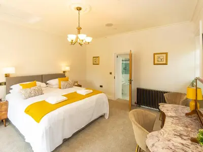 a bedroom with a large bed and a table at Old Rectory House in Newtown