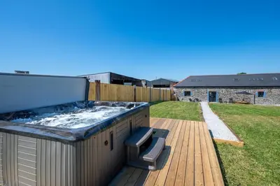 a hot tub on the deck of a backyard at 4 Bed in Aberystwyth oc-bow304 in Rhostie