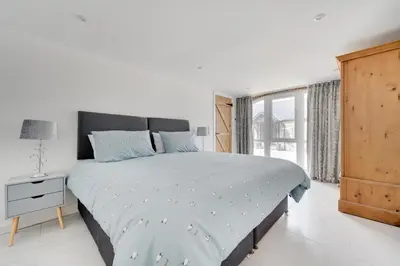 a white bedroom with a large bed and a window at 4 Bed in Aberystwyth oc-bow304 in Rhostie