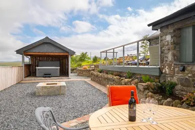 an outdoor patio with a table and a fireplace at 3 Bed in Trawsfynydd oc-wag718 in Trawsfynydd