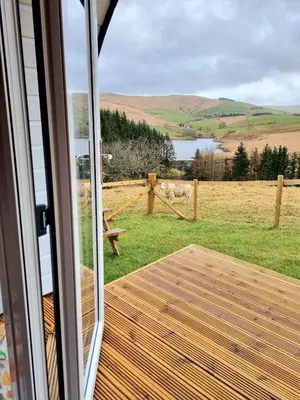 a view from a sliding glass door of a horse pasture at Forester's Retreat Glamping - Dinas View - Vaccinated dogs over the age of 2 are accepted in Aberystwyth