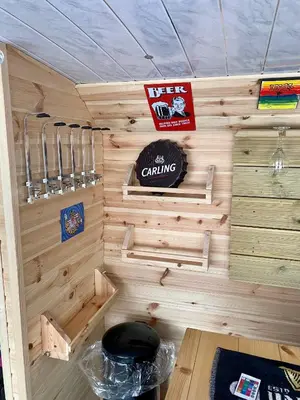 a wooden cabin with a sign on the wall at Double Decker Bus in Aberystwyth