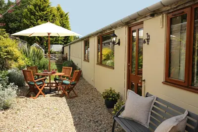 a patio with a table and chairs and an umbrella at Great Western Lodge at Eaton Manor in Eaton