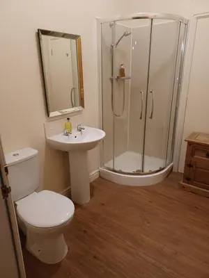a bathroom with a shower and a toilet and a sink at Great Western Lodge at Eaton Manor in Eaton