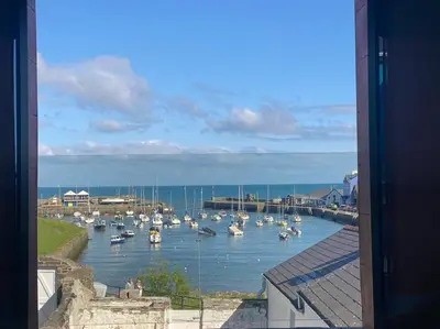 a view of a harbor with boats in the water at Aberaeron Island House - Panoramic Harbour Views in Aberaeron