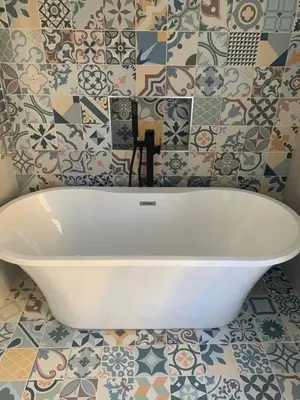 a white bath tub in a bathroom with tiles at Aberaeron Island House - Panoramic Harbour Views in Aberaeron