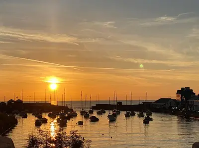 a group of boats in the water at sunset at Aberaeron Island House - Panoramic Harbour Views in Aberaeron