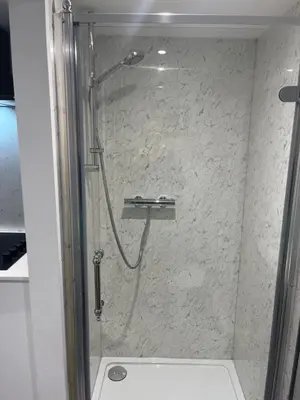 a shower with a glass door in a bathroom at Harbour Apartment in Barmouth