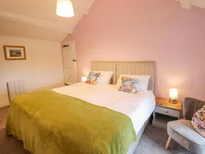 a bedroom with a large bed and a chair at Preswylfa in Blaenau-Ffestiniog