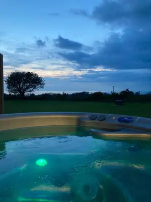 a pool of water with a tree in the background at MAESLLAN CABINS 'Hud Y Machlud' in Cross Inn