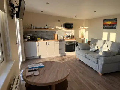 a living room with a couch and a table at MAESLLAN CABINS 'Hud Y Machlud' in Cross Inn